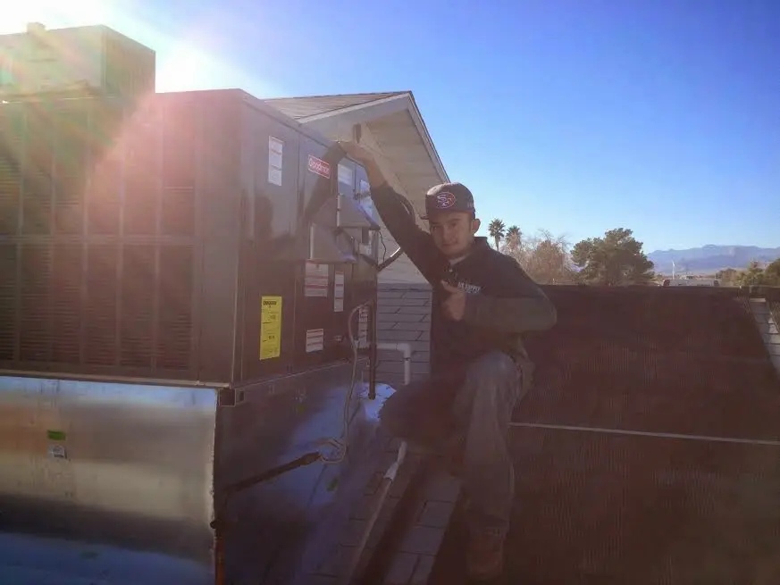 HVAC technician performing AC Tune-Up on a rooftop unit in Lake City